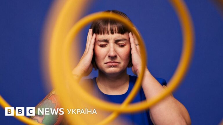 жінка з мігренню в темній кімнаті здоров'я